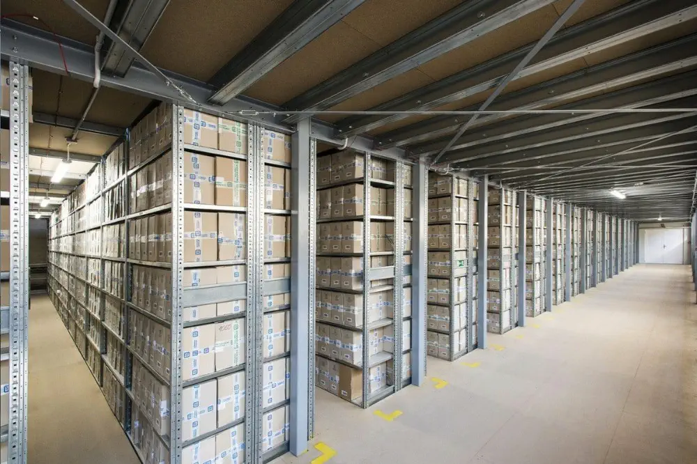 Patrové ocelové regály s archivními krabicemi ve spisovně ARCHIVUM